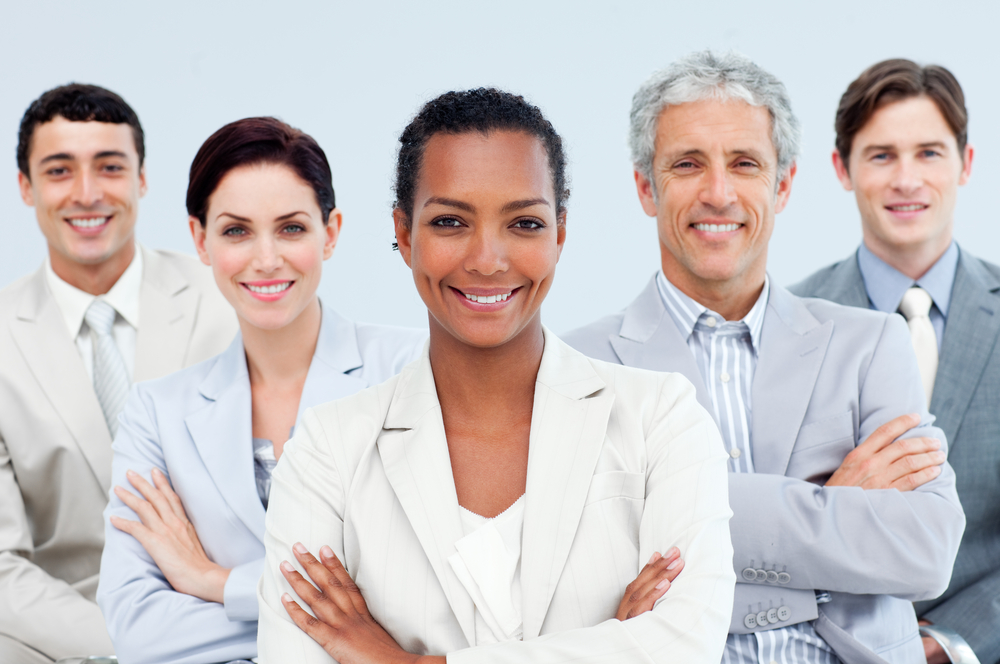 Diverse business people standing with folded arms smiling at the camera